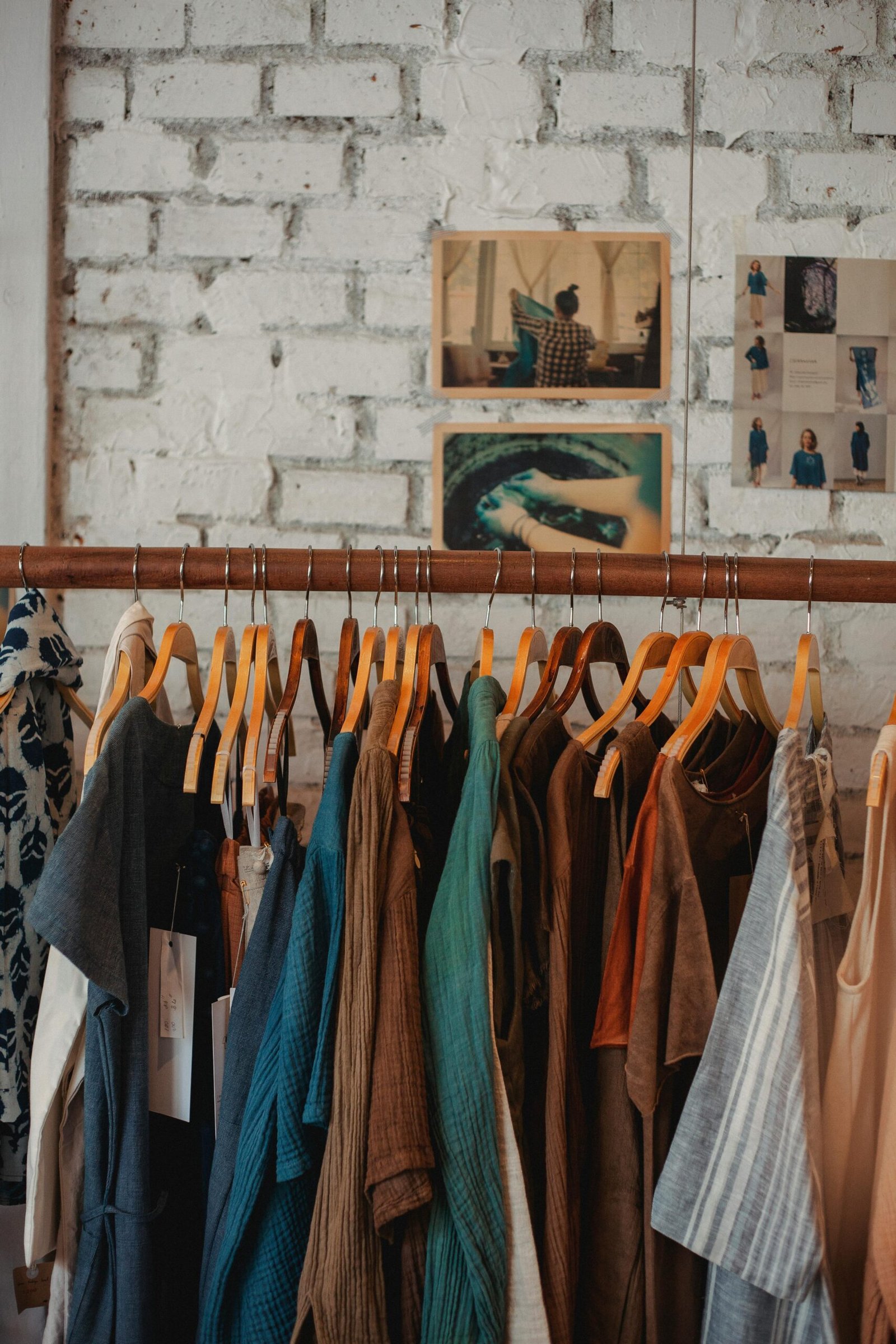 Colorful assortment of clothes on wooden hangers in a trendy boutique.