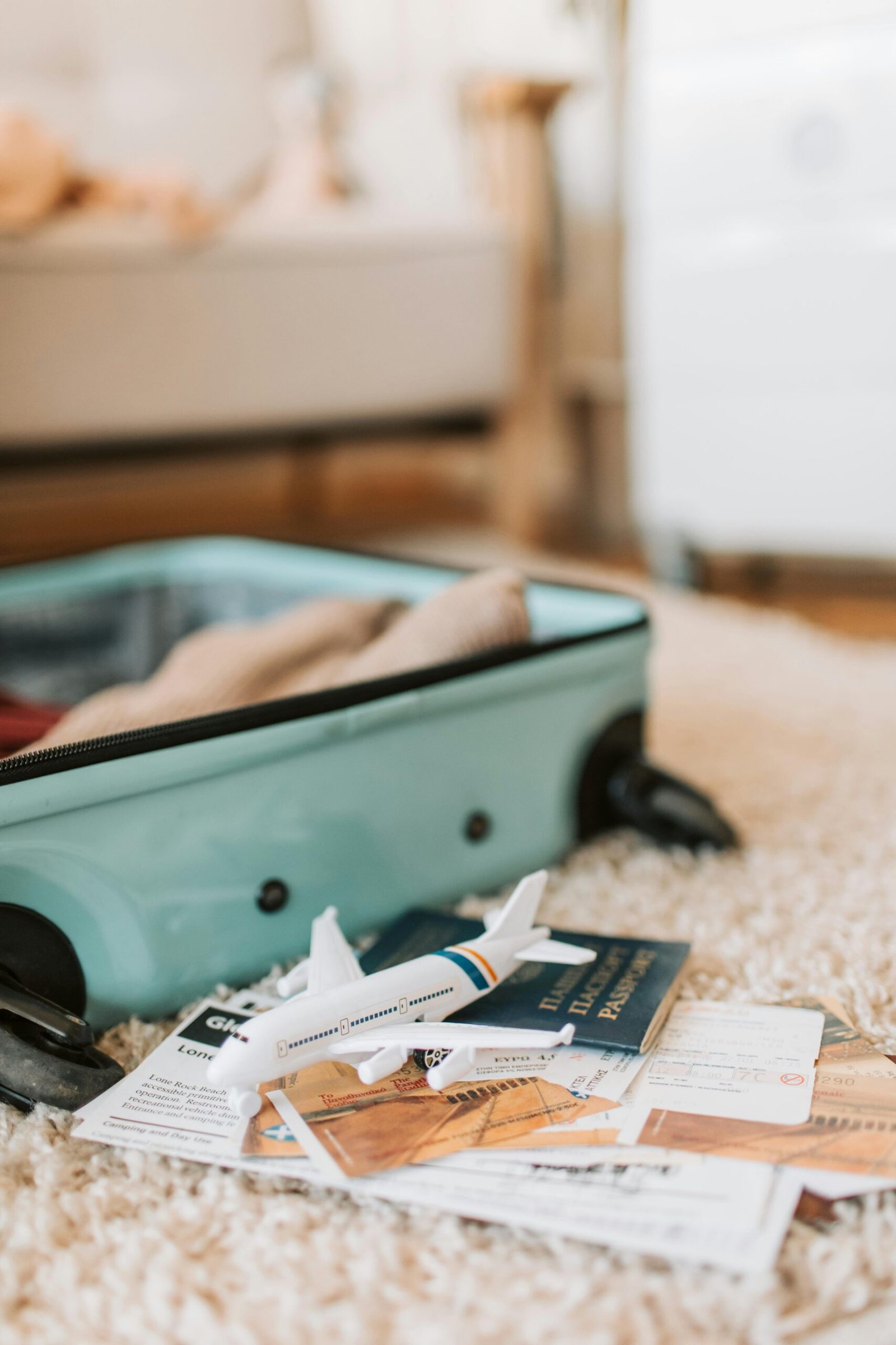 Open suitcase with travel documents and a toy plane, evoking a sense of adventure.